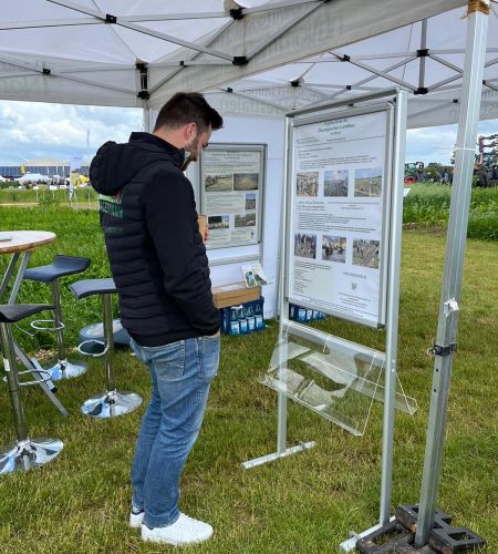 Ein Besucher der Feldtage studiert ein Poster.